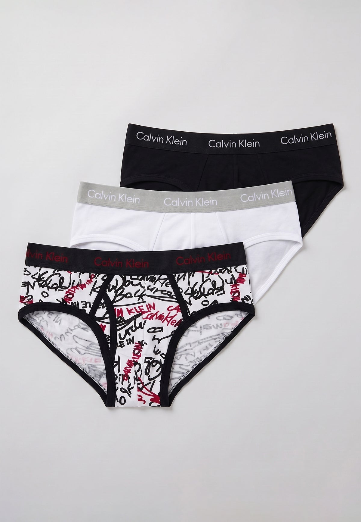 Pack de 3 slips Calvin Klein — exemple d'assortiment : noir, blanc et imprimé graffiti